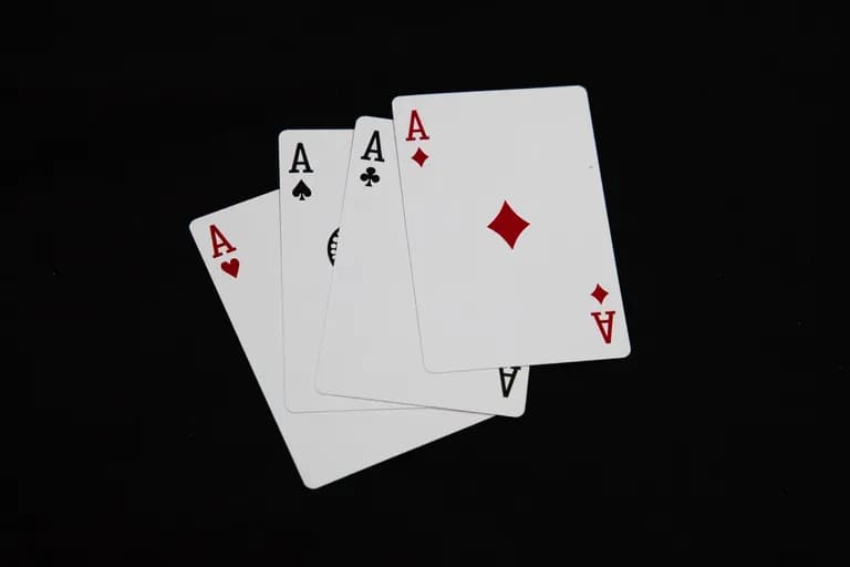 Empat daun ace dibentangkan pada permukaan hitam