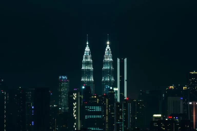 Menara Berkembar Petronas bercahaya pada waktu malam di atas kaki langit Kuala Lumpur